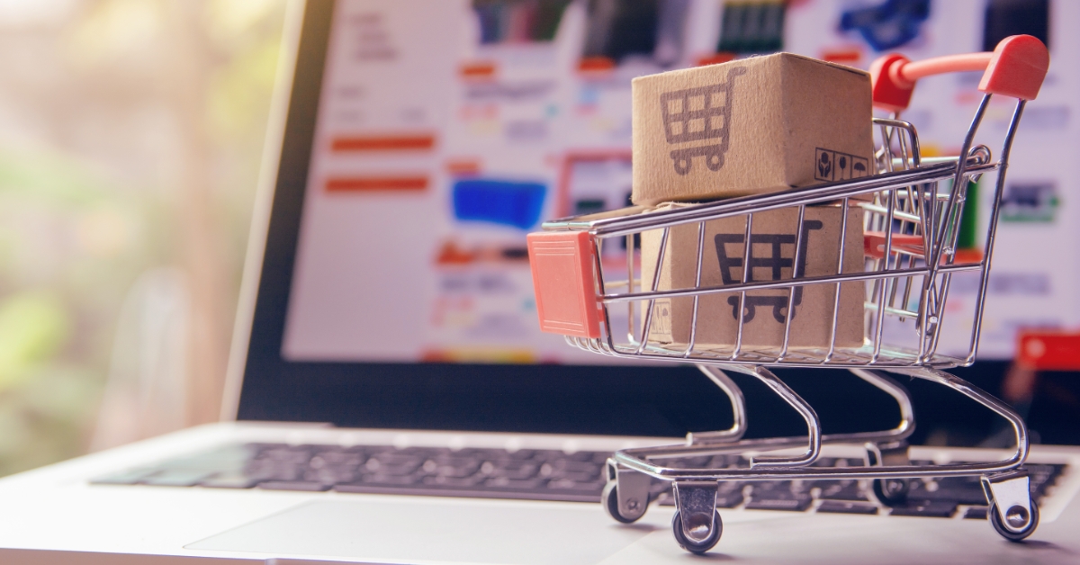 Image of a mini shopping cart by a laptop